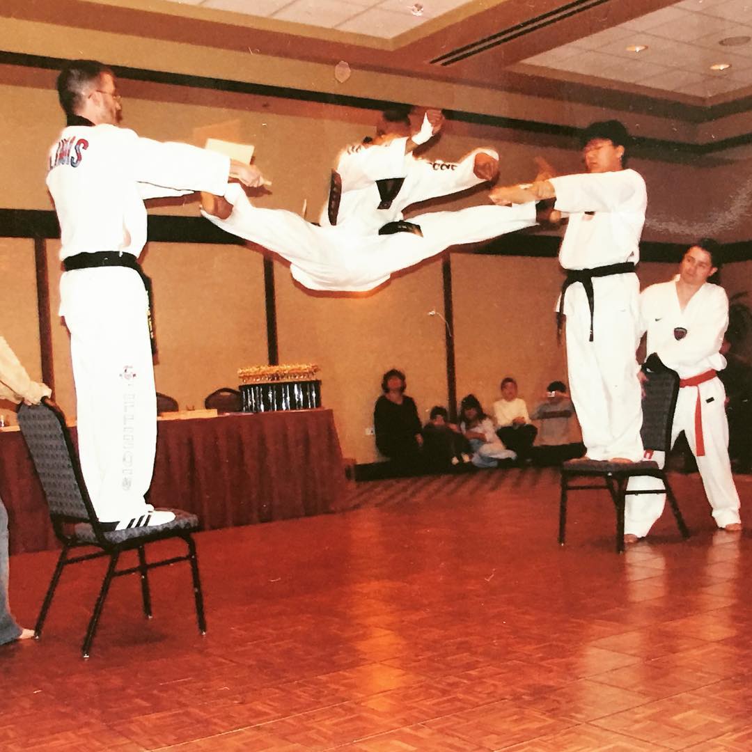 Master Virgil Greer performing a flying split kick during a martial arts demonstration