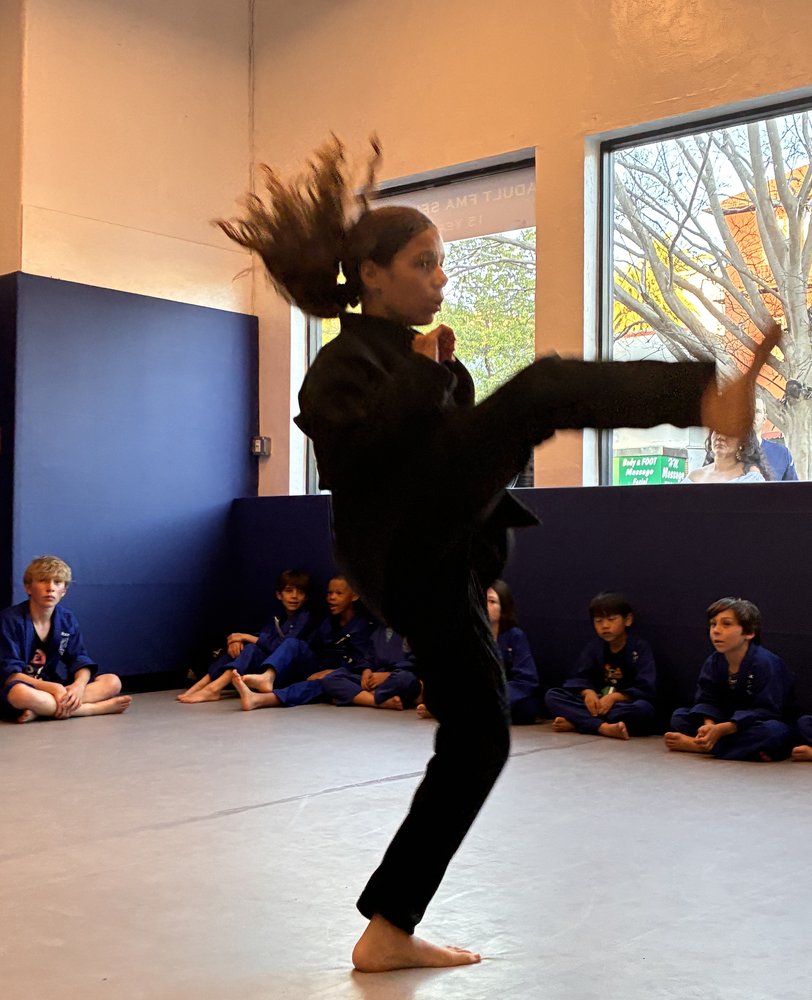 Student practicing a high kick in class at Bay Area Martial Arts in Oakland