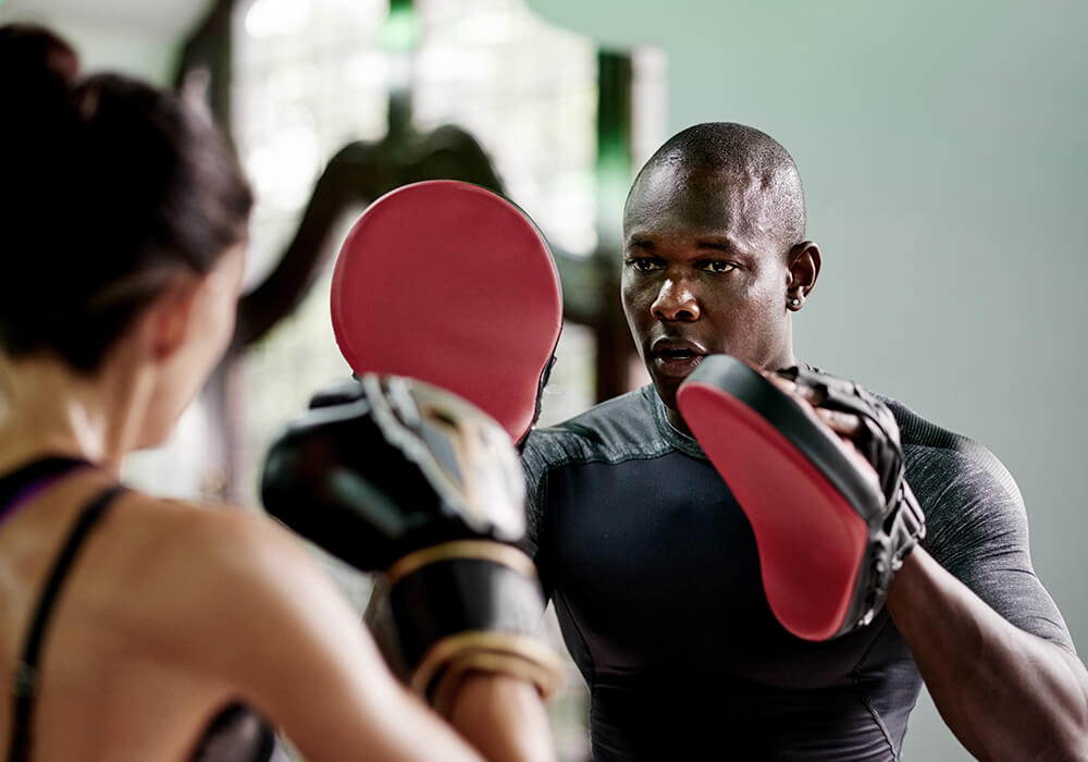 Action shot, Trainer and Female Athlete Practicing Striking Combos