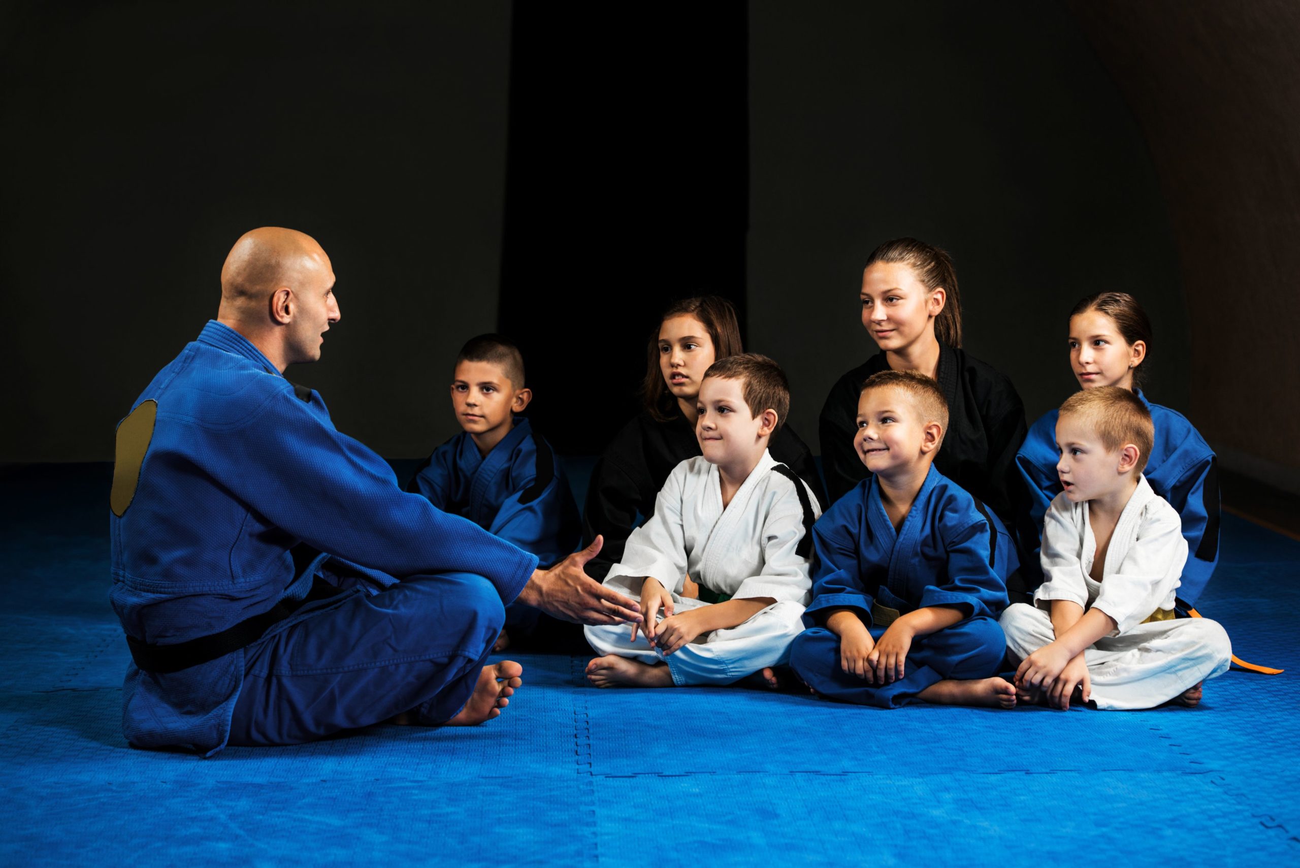Coach and students discussing BJJ techniques.