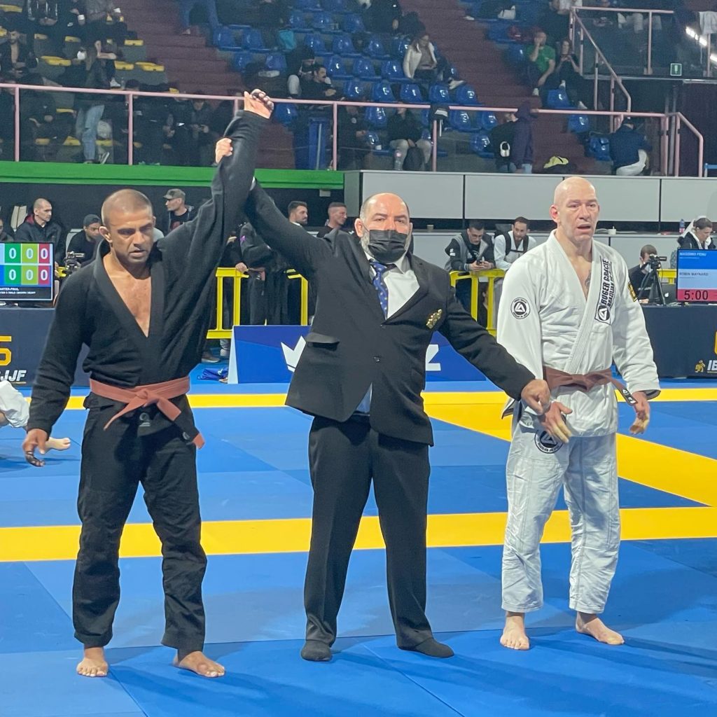 Brazilian jiu jitsu brown belt getting his hand raised by referee