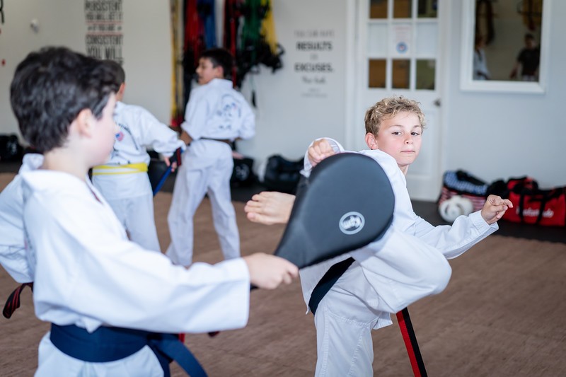 U.S. Elite martial arts students practicing kicks with a training pad