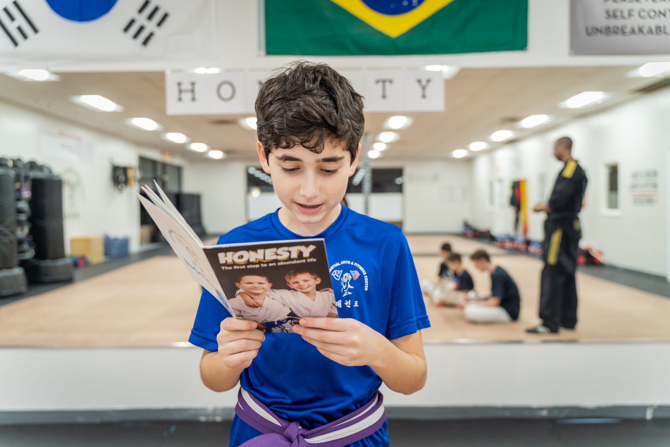 A U.S. Elite student standing and reading from the Honesty life-skills booklet during class