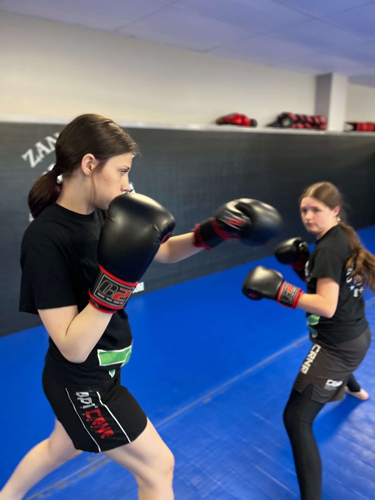Two teen students practicing boxing with gloves at Championship MMA